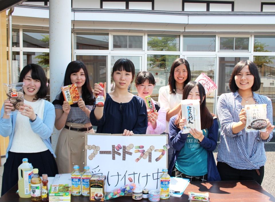 写真：フードドライブで集めた食料品を手にする学生たち