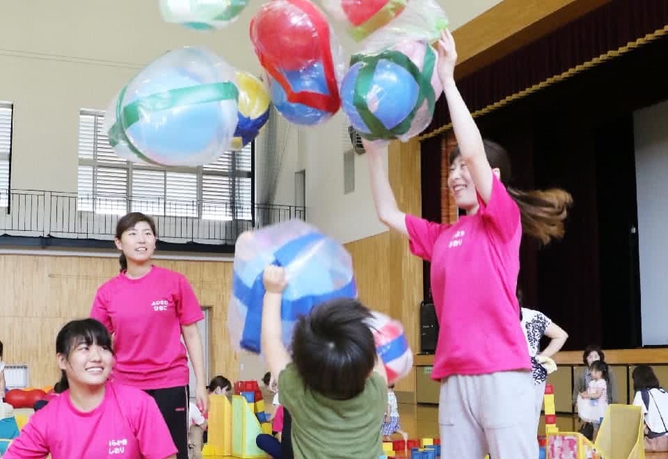 写真：手作りの遊具で遊ぶ子どもと学生