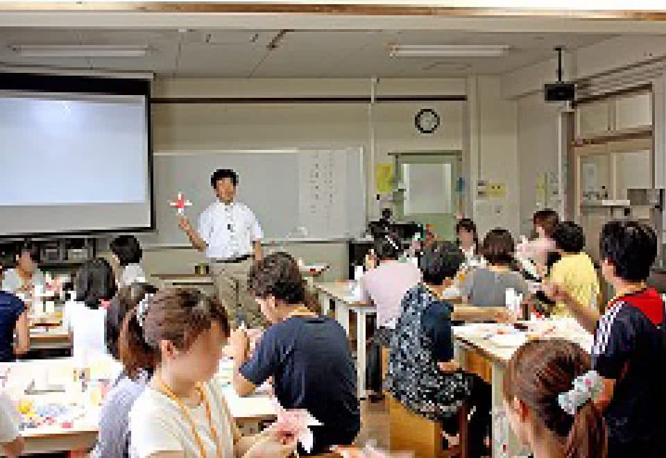 写真：研修会にて手作りおもちゃの作り方を指導する講師と受講する参加者