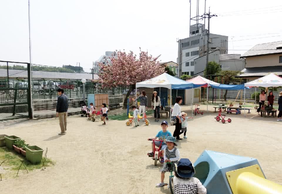 写真：附属幼稚園の園庭で遊ぶ子どもと保護者