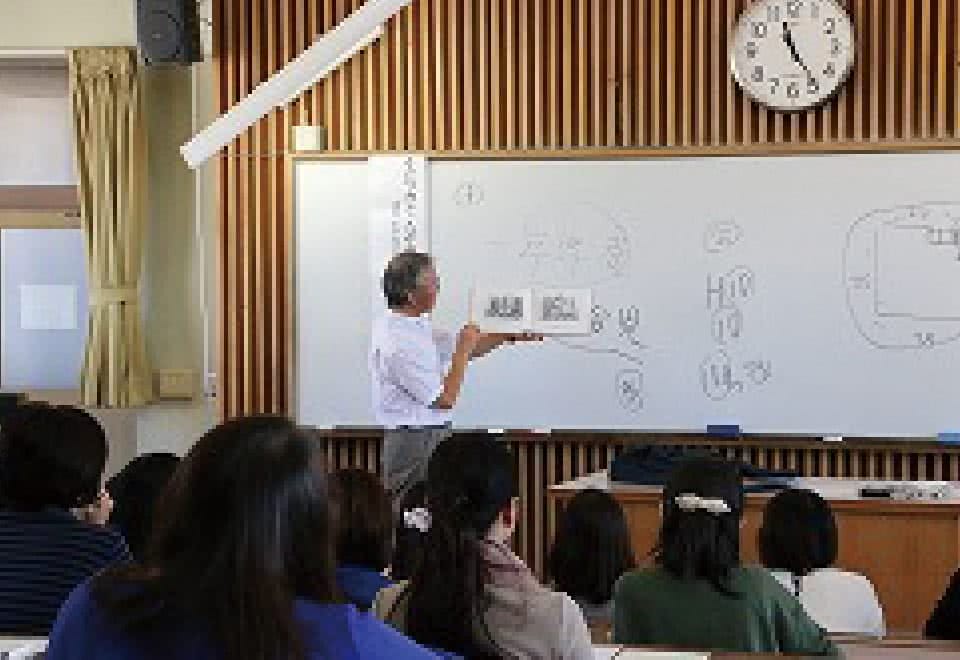 写真：講座にて絵本について講演する講師と、受講する参加者