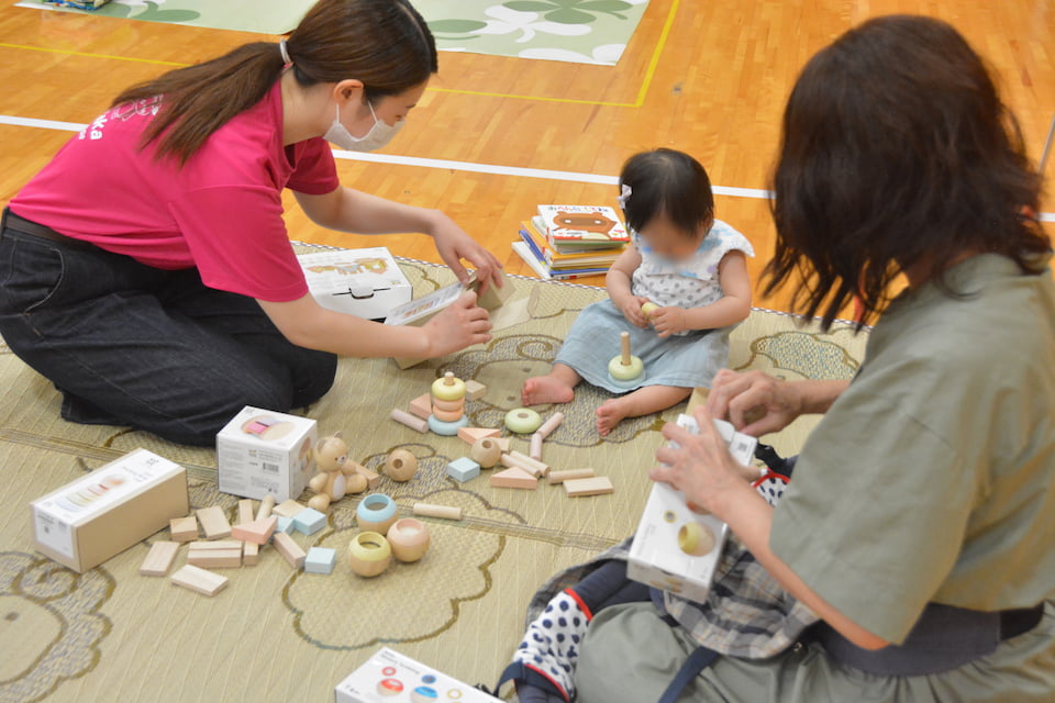 写真：おもちゃで遊ぶ親子と学生の様子