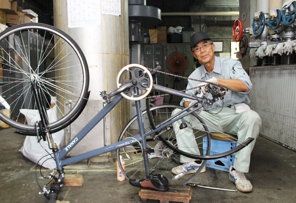 写真：自転車の修理をする男性の校務員さん