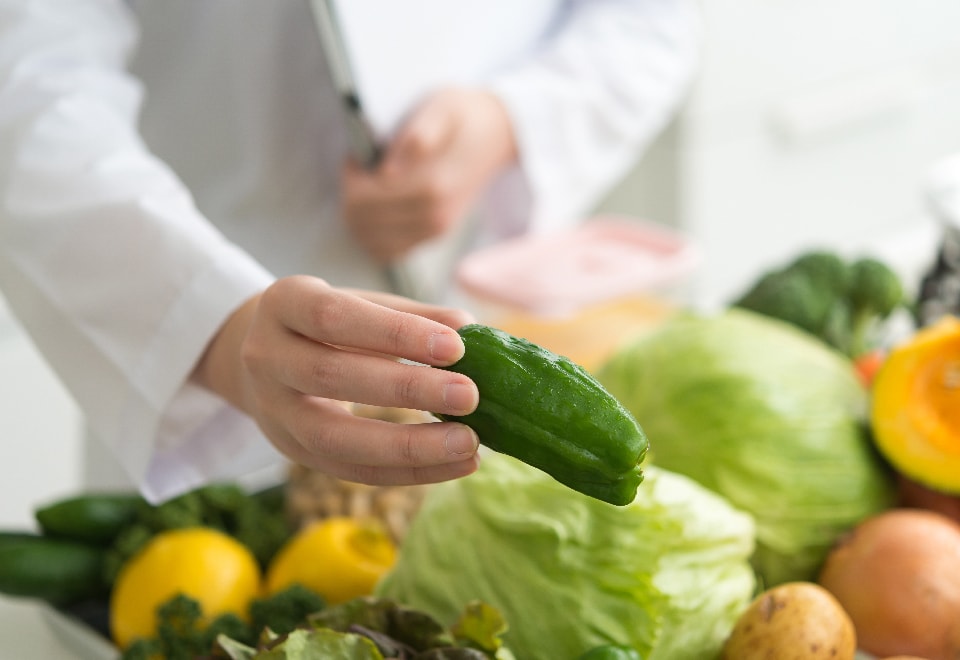 写真：沢山の野菜の中からピーマンを手に持つ様子
