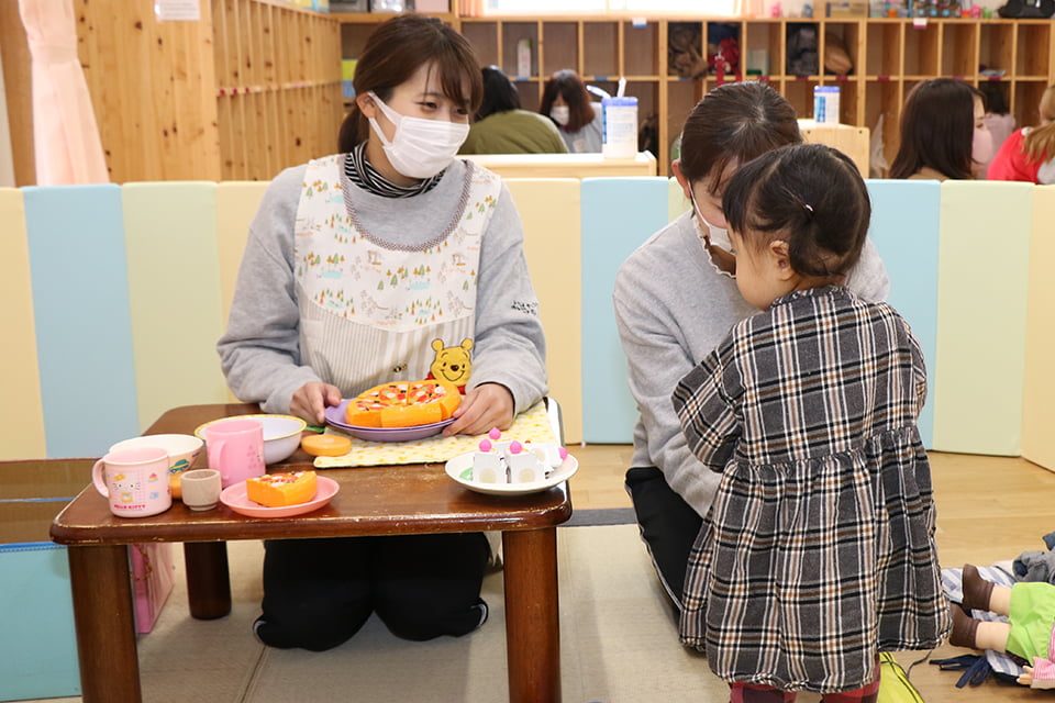 写真：子どもと遊ぶ2人の学生の様子