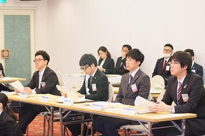 写真：熱心に学生の説明を聞く参加者