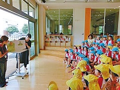 写真：イソップくらぶの活動として、園児たちに絵本の読み聞かせを行う二人の保護者