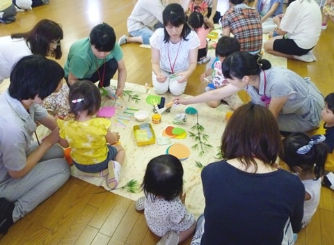 写真：七夕の飾り付けを作る子どもたちと保護者たち