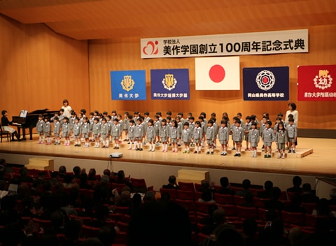 写真：美作学園100周年記念に参加し、檀上でピアノの演奏に合わせて合唱する園児たち
